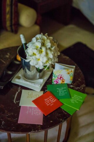 Hochzeitsdeko auf Seychellen mit Blumengruß und Weinflasche.